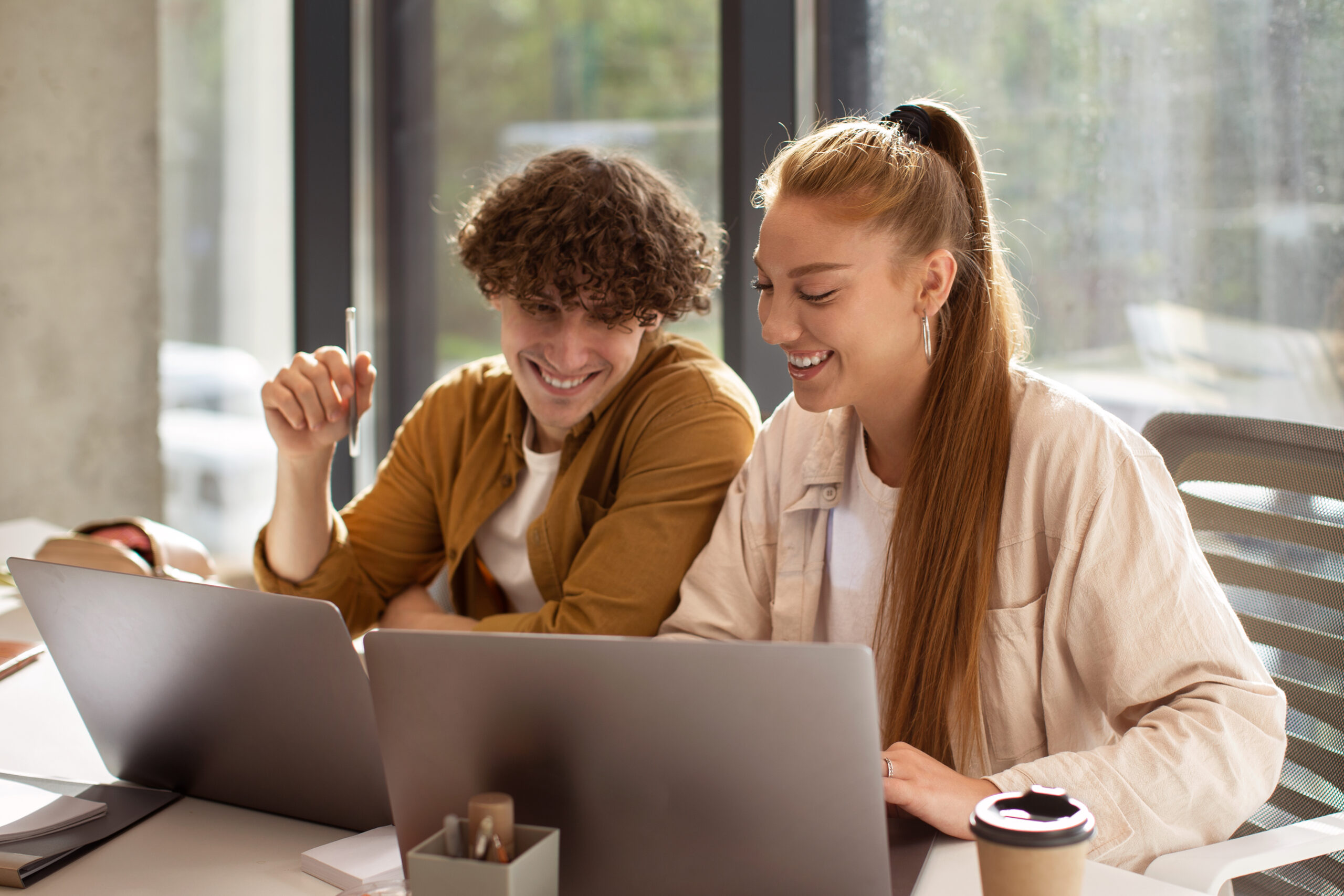 When to Pause or Adjust Your PPC Ads 1 Man and woman working on laptops