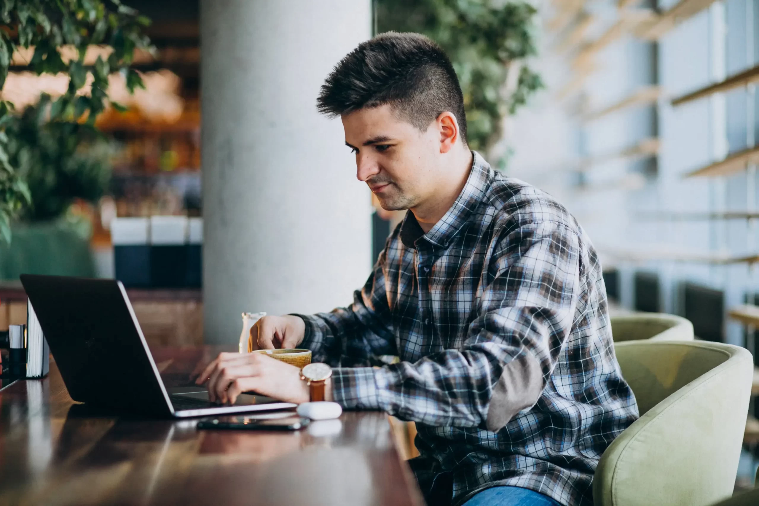 A man using a laptop at a cafe.