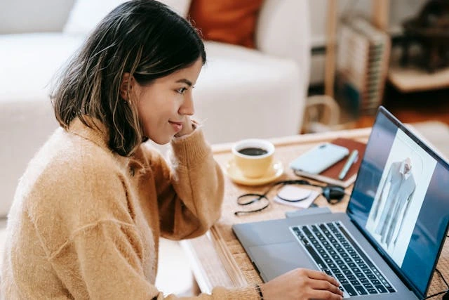 A woman browsing an online store using her laptop.